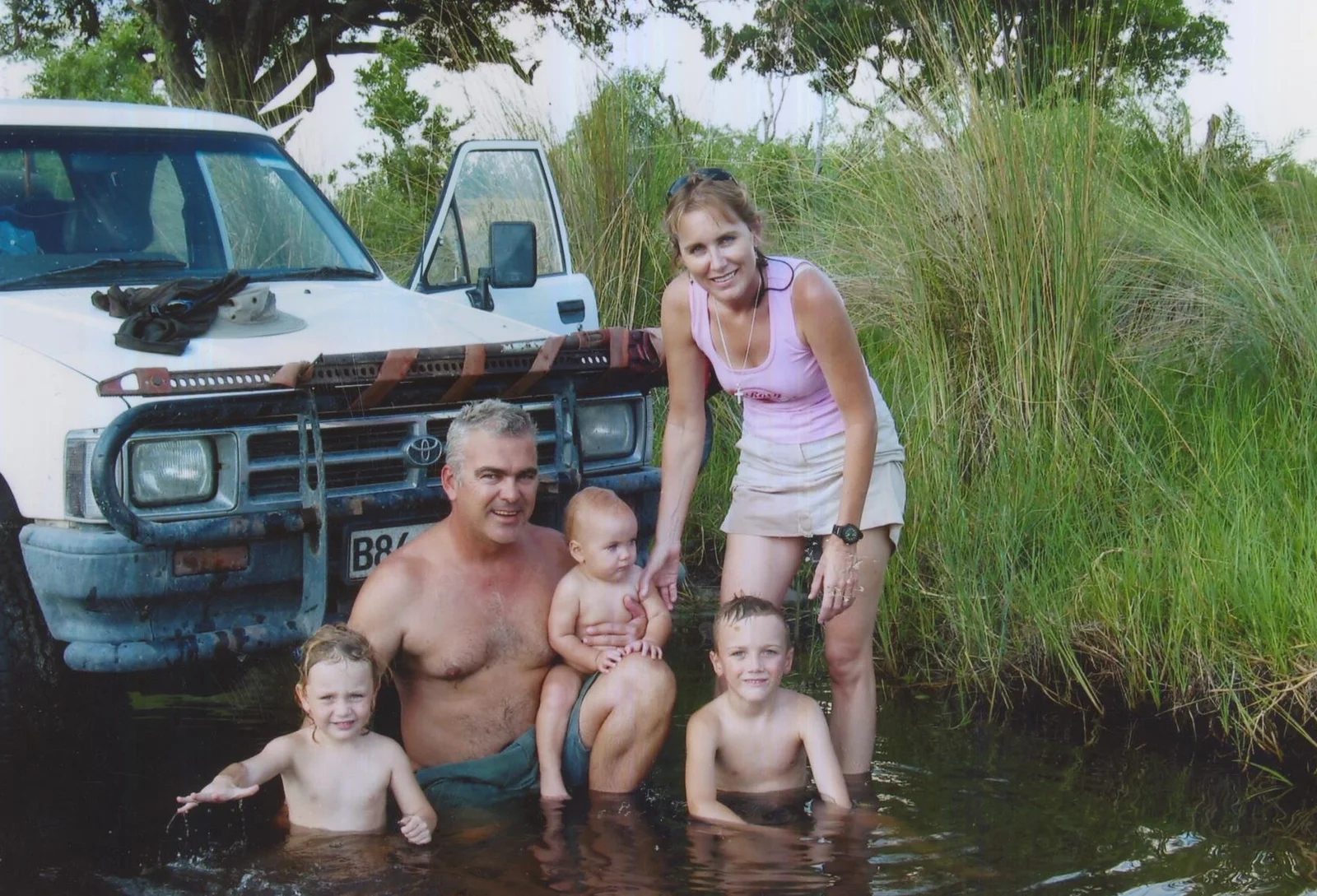 Jake with his family beside a safari vehicle