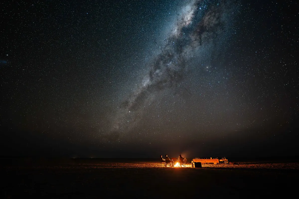 Travellers stargazing beside a Botswana wetland